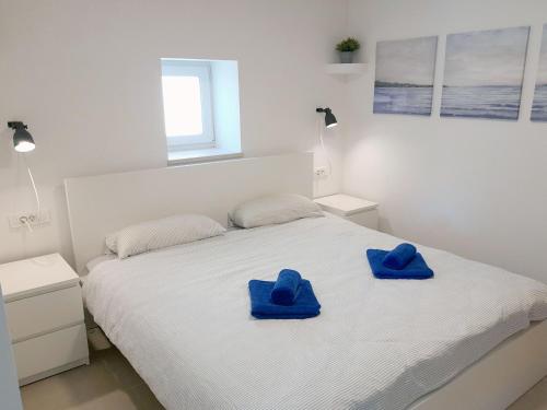 木洛希尼Apartment House Bucul的白色的床,上面有蓝色的毛巾