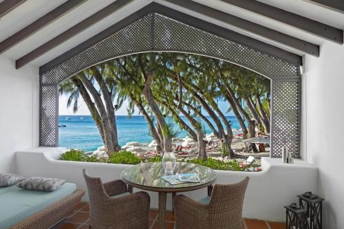 圣詹姆斯Colony Club by Elegant Hotels的配有桌子并享有海滩景色的客房
