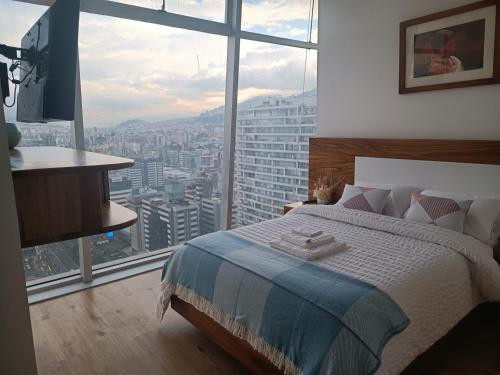 基多Hermoso Penthouse Vistas Espectacular的一间卧室设有一张床和一个大窗户