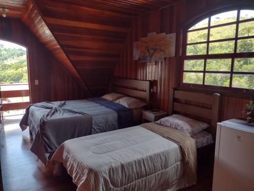 坎波斯杜若尔当Casa do Trem Suítes的一间带两张床的卧室,位于带窗户的房间内