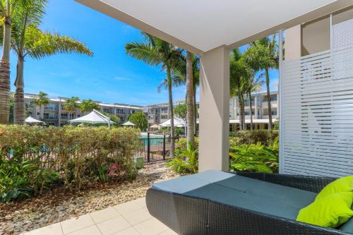 金斯克里福Peppers Salt Resort & Spa - Lagoon pool access 2 br spa suite的一个带长凳和棕榈树的庭院和一个游泳池