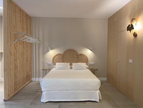 卡莫纳VIDAL APARTAMENTOS con parking privado.的一间卧室配有一张带白色床单的大床