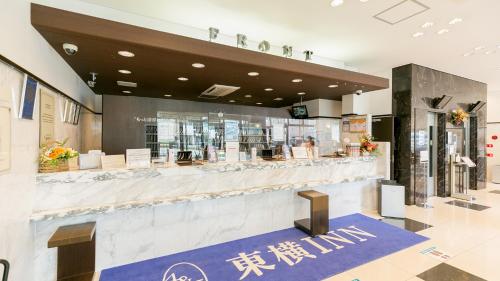 鹿儿岛Toyoko Inn Kagoshima chuo eki Nishi guchi的大楼内带柜台的餐厅