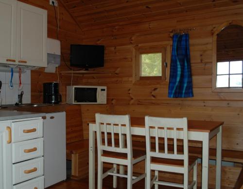 PyhäjärviEmolahti Camping的小屋内的厨房配有桌椅