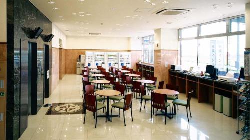 北九州Toyoko Inn Kitakyushu Airport的餐厅内带桌椅的用餐室
