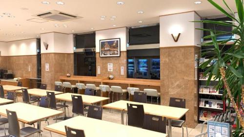 福冈Toyoko Inn Hakata Nishi-nakasu的餐厅内带桌椅的用餐区