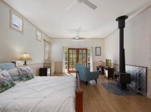 巴尼维尔Barney Creek Vineyard Cottages的一间卧室设有一张大床和一个壁炉