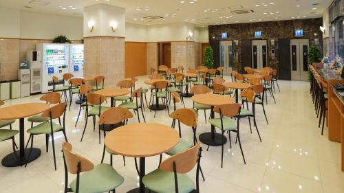 熊本Toyoko Inn Kumamoto Ekimae的自助餐厅内带桌椅的餐厅