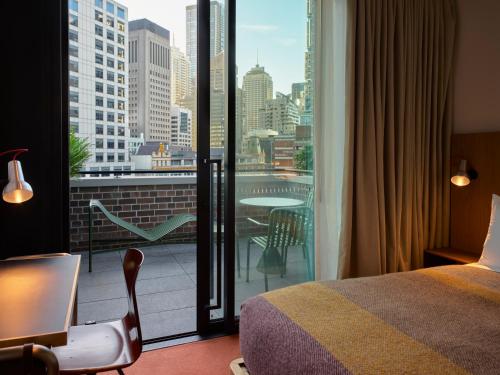 悉尼Ace Hotel Sydney的酒店客房设有一张床和一个美景阳台