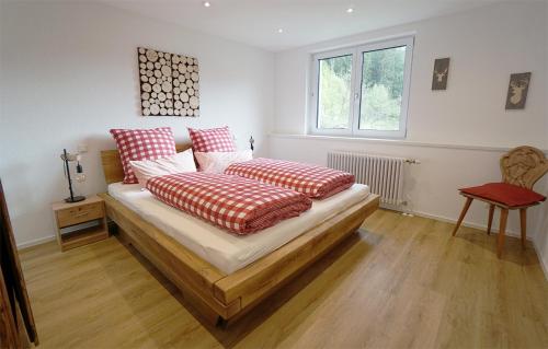 西蒙斯瓦尔德Gummeneck - Stubenhof, Black Forest的一间卧室配有红色和白色枕头的床