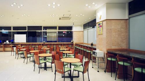 福井Toyoko Inn Fukui Ekimae的一间空餐厅,里面摆放着桌椅