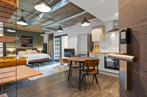 伦敦Modern and Chic Apartments at Ferrum near Wembley Park的厨房以及带床和桌子的客厅。