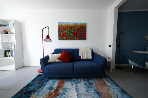 拉文纳Domus Silvana Apartments的客厅里一张蓝色的沙发,上面有绘画作品