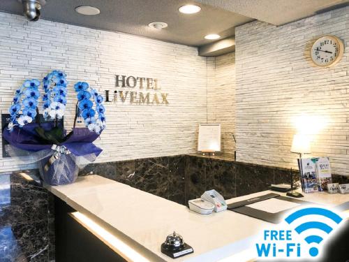 名古屋HOTEL LiVEMAX BUDGET Nagoya Taikodori的酒店大堂设有蓝色鲜花的前台