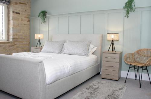 哈德斯菲尔德文化遗址服务式套房-服务式公寓酒店的卧室配有白色的床和两盏灯。