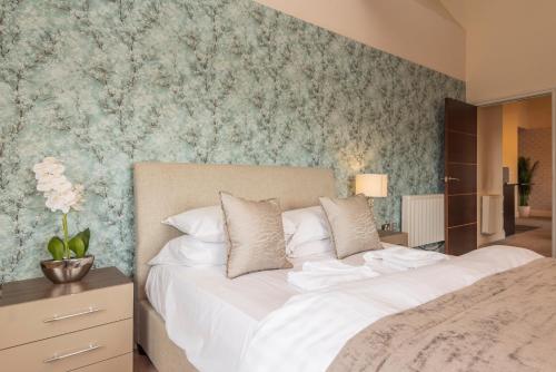 哈德斯菲尔德文化遗址服务式套房-服务式公寓酒店的卧室配有一张白色大床和花卉壁纸