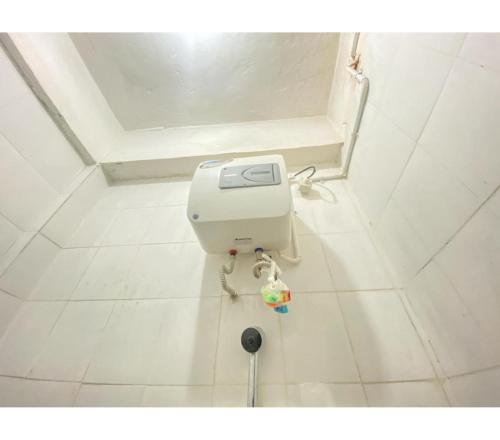 SaroakoTransisco Hotel Sorowako Mitra RedDoorz的白色瓷砖浴室内的白色卫生间