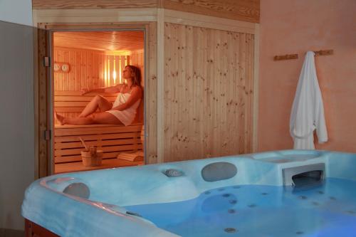 莱瓦尔坦维特尼酒店的坐在一个房间里浴缸里的女人
