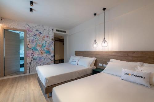 古比奥卡缇纳诺酒店和餐厅的墙上有地图的房间的两张床