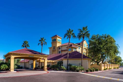 皮奥里亚凤凰城西皮奥里亚拉昆塔套房酒店的一座拥有钟楼和棕榈树的建筑