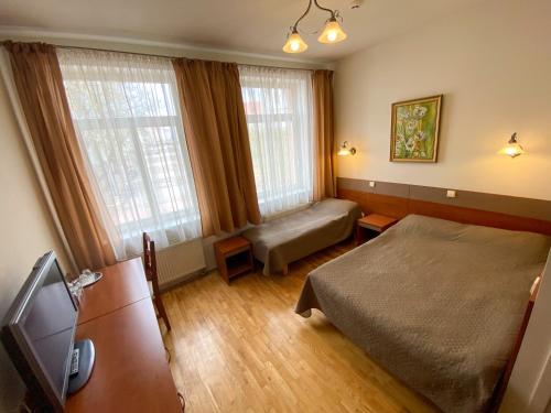 特尔希艾Pas Stefą的一间卧室配有一张床、一张沙发和两个窗户。