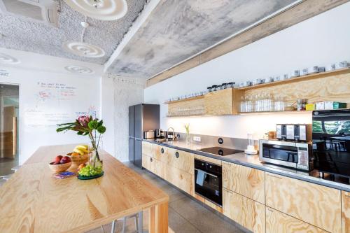 德鲁斯基宁凯Tech Spa Coliving&Coworking Spaces的一个带木制橱柜和木桌的大厨房