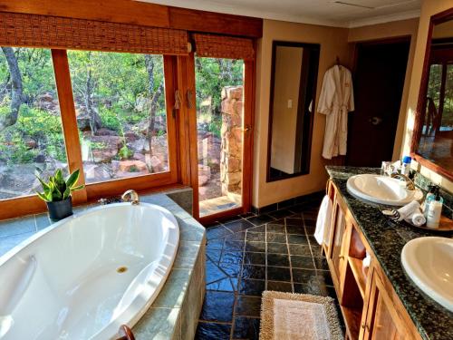 威尔吉旺登禁猎区Sekala Private Game Lodge的大型浴室设有两个盥洗盆和浴缸。