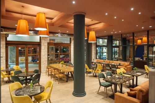 特尔斐巴纳索斯德尔菲酒店的餐厅设有桌椅和窗户。