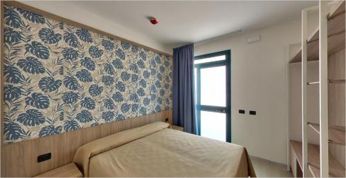 MercalloAquasole的一间卧室配有一张蓝色和白色壁纸的床