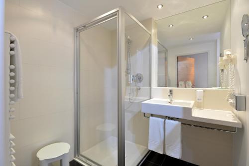 瓦滕斯金色阿德勒瓦腾斯酒店的带淋浴和盥洗盆的白色浴室