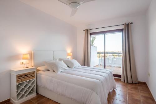 拉海瑞德拉Carmen de la Bahía的白色的卧室设有一张大床和一个窗户