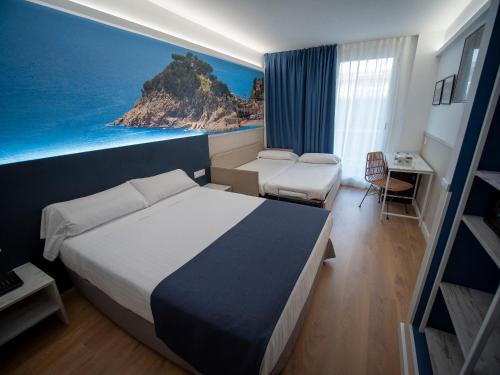 滨海托萨唐璜托萨酒店的酒店客房配有一张床和一幅海洋画