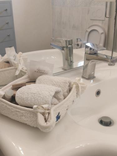 卡尔米尼亚诺Dépendance in Villa Albachiara e Primaluce的浴室水槽配有毛巾和水龙头