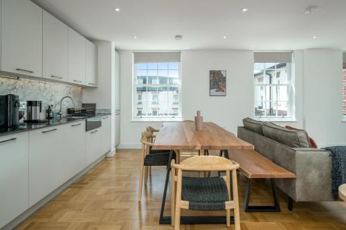 伦敦JOIVY Spectacular 3-bed flat near Holland Park的厨房以及带桌子和沙发的客厅。