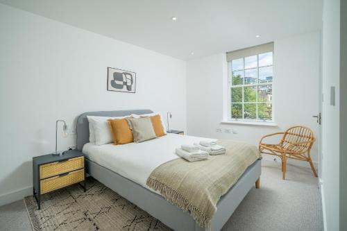 伦敦ALTIDO Spectacular 3-bed flat near Holland Park的白色卧室配有床和椅子