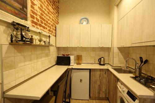 第比利斯Luky apartment on Rustaveli Ave.的厨房配有白色橱柜和水槽