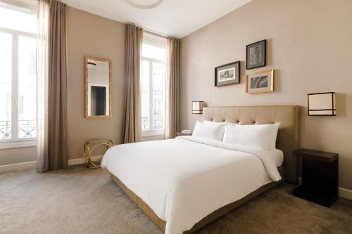 巴黎弗罗绍歌剧院酒店的卧室设有白色大床和窗户。