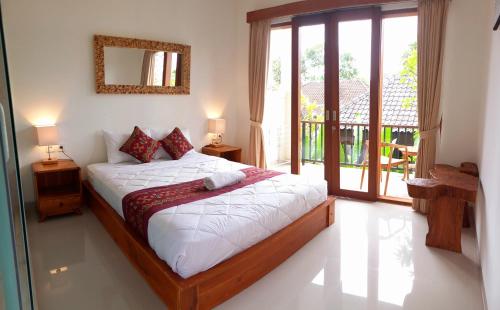 乌布D'JERO HomeStay的一间卧室配有一张带白色床单的床和一扇窗户。
