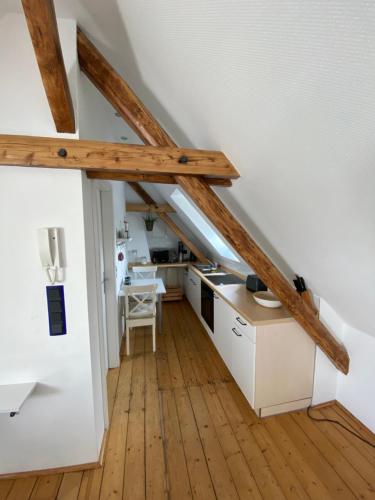 杜塞尔多夫Messeapartment Stockum的阁楼厨房设有白色橱柜和木梁。