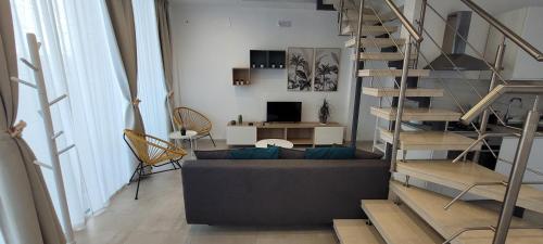 锡拉库扎Eos Sea View Apartments的带沙发和螺旋楼梯的客厅