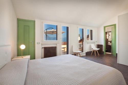 加尔达Villa Brancolin的一间带白色床的卧室和一间带窗户的房间