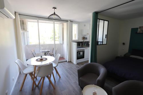 格雷乌莱班Studio tout confort - Climatisation, parking, wifi的小型客厅配有桌椅