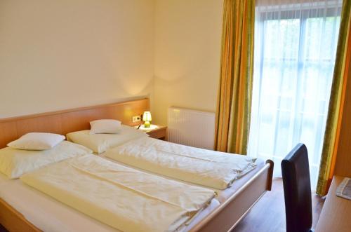 施特罗布尔霍费巴乌古特酒店的带窗户的客房内的两张床