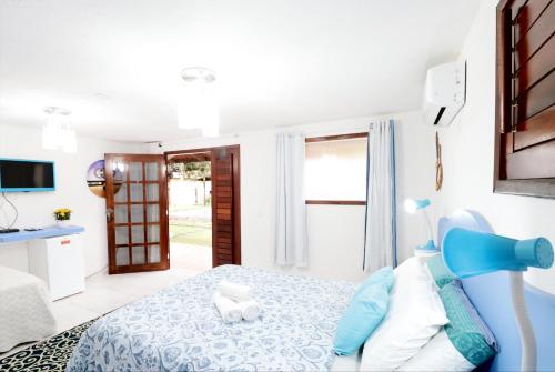 帕拉库鲁Paracuru Kitefriends Lux Pousada的一间白色的卧室,配有蓝色的床和一扇门