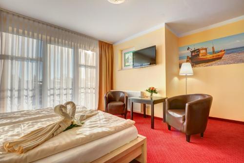 塞巴特阿尔贝克斯特兰得胡斯公寓式酒店的酒店客房,配有一张床、一张桌子和椅子