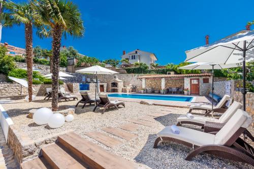克尔克Villa Palma Krk的一座别墅,设有游泳池和棕榈树