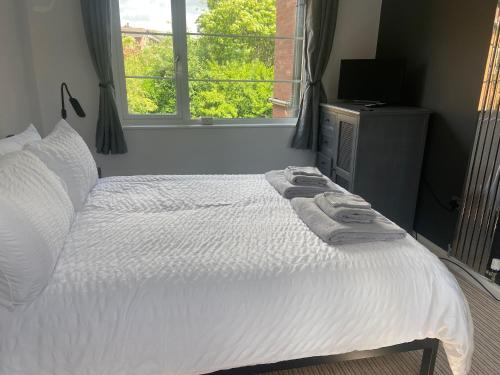 埃文河畔斯特拉特福Stratford Upon Avon Pearl的一间卧室配有一张带白色床单的床和一扇窗户。
