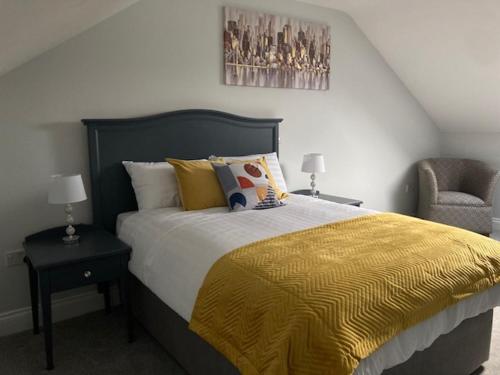 CastlepollardLir Lodge的一间卧室配有一张带黄毯和椅子的床