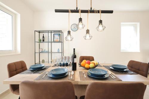 沃迪切Holiday house Antulov的一间用餐室,配有一张带蓝色盘子和椅子的桌子