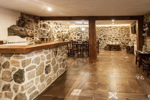 El Real de San VicenteCasa Rural La Fontanita的一间拥有石墙的餐厅和一间酒吧